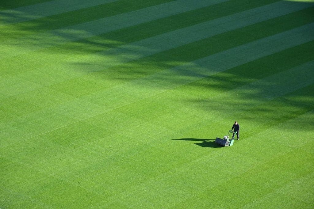 man mowing a beautiful grass field