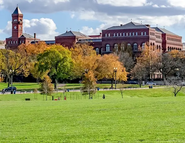 Large, beautiful commercial lawn, in front of brick buildings